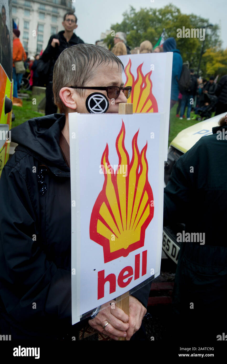 London October 12th 2019  Extinction Rebellion Funeral March from Marble Arch. Protester with placard saying Hell and burning Shell symbol. Stock Photo