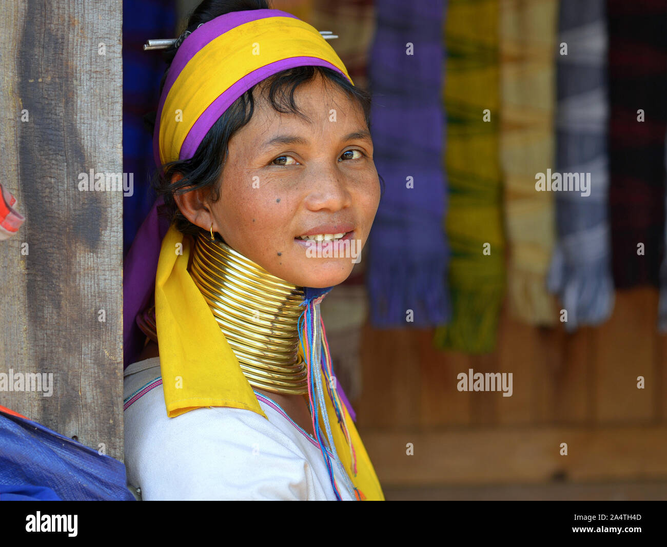 Myanmarese Kayan Lahwi woman ("giraffe woman”) with tribal brass neck rings/coils smiles for the camera. Stock Photo