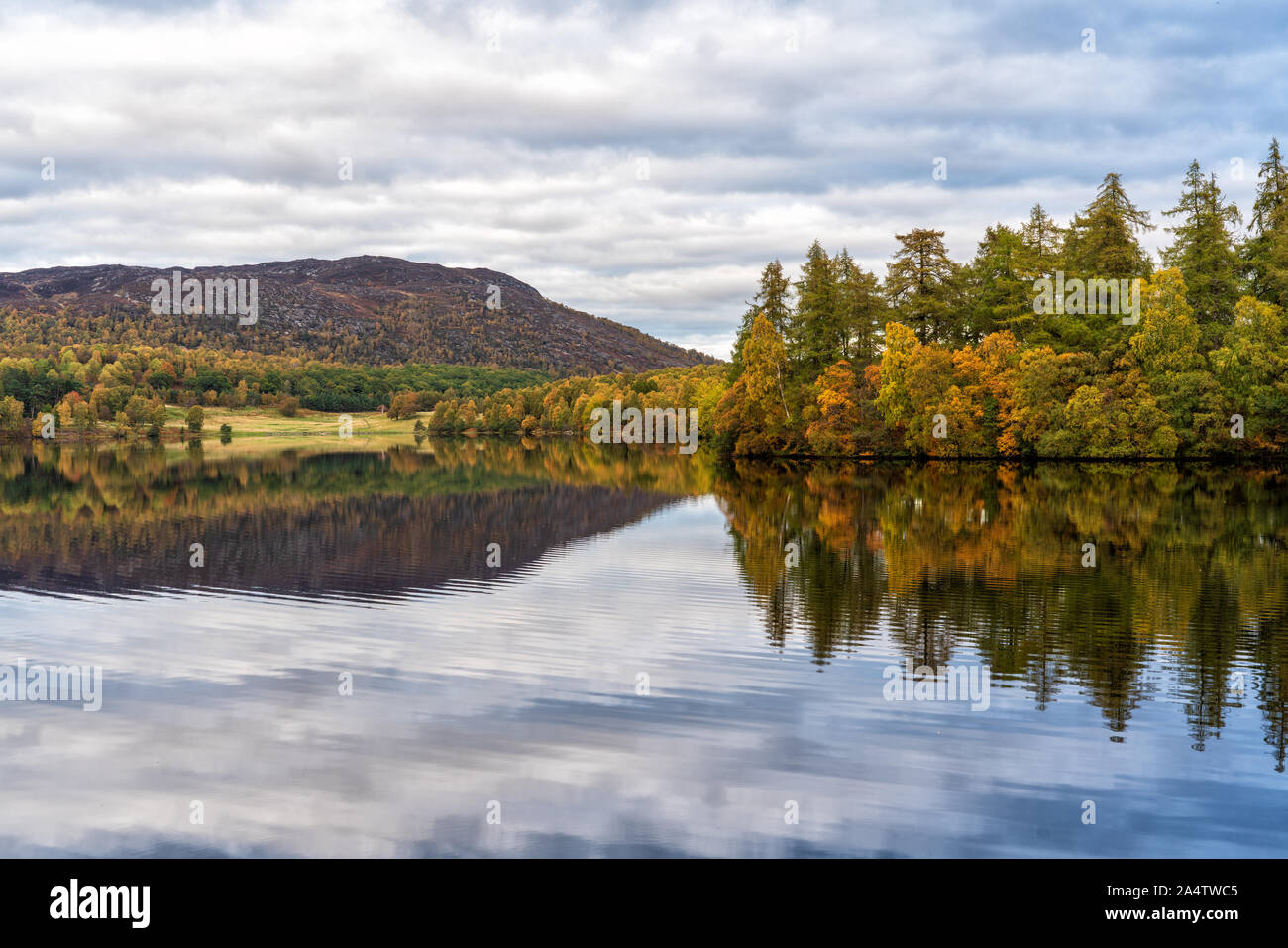15 October 2019. Loch Alvie, Aviemore, Highlands, Scotland, UK. This is Loch Alvie mirroring the Autumn Colours in the last hour of daylight. Stock Photo