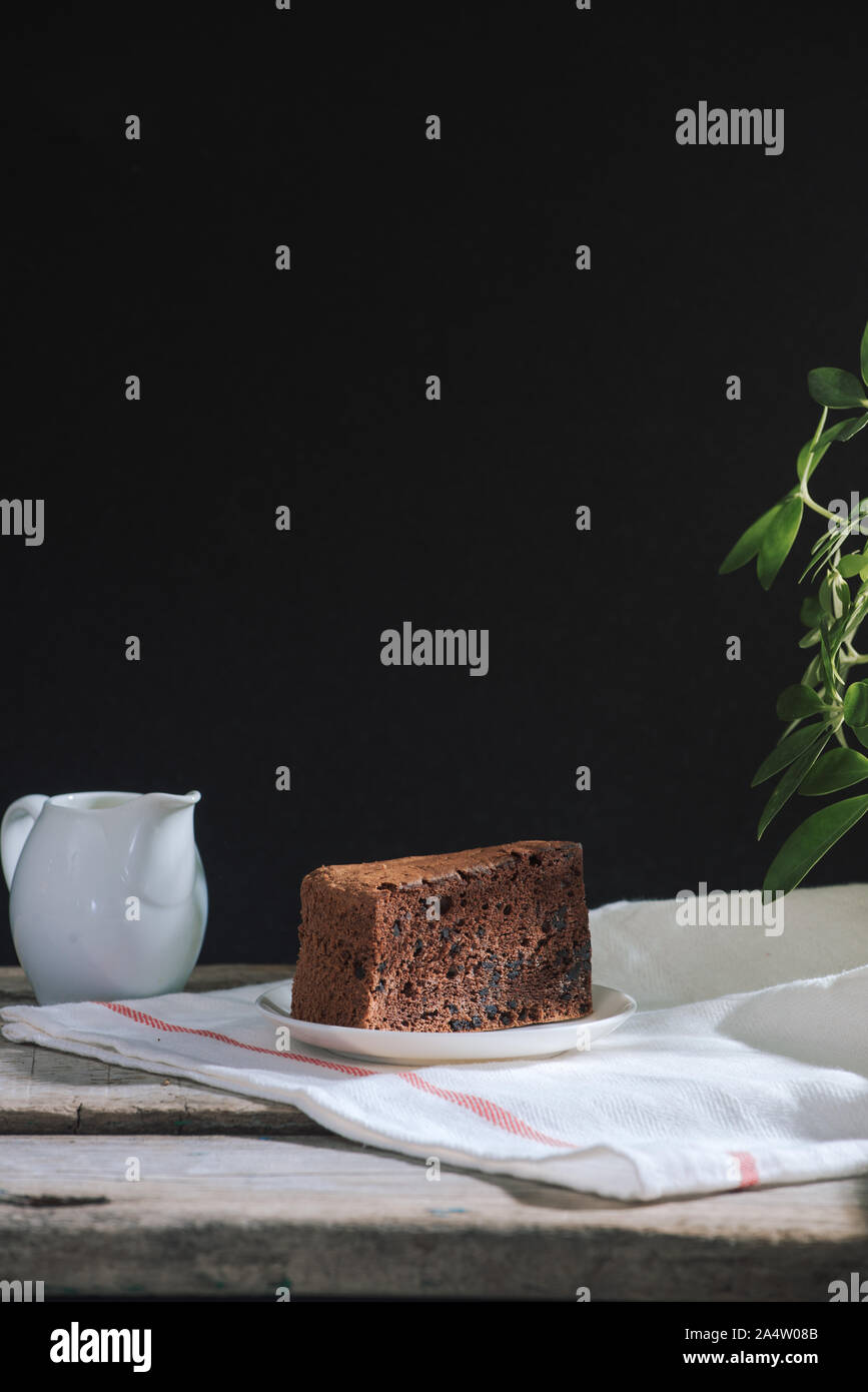 Drip brewing coffee concept. Wooden desk with chocolate cake and cup of