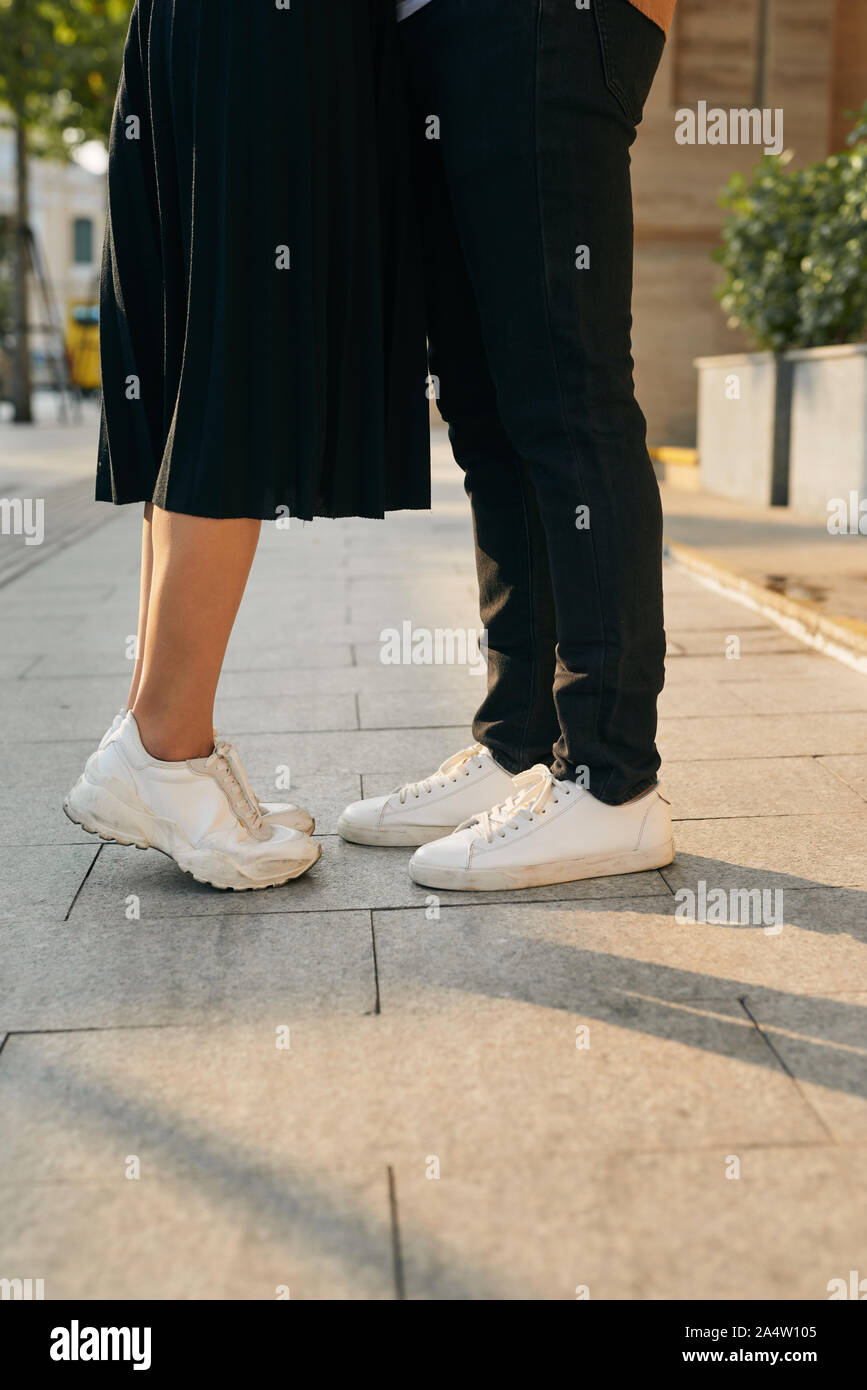girls stands on tiptoe to kiss her man - Close up on shoes Stock Photo