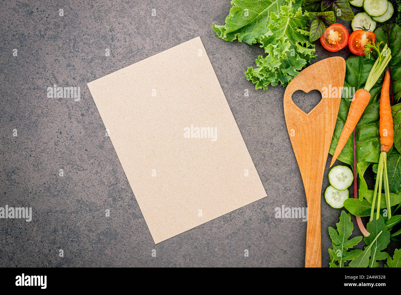 Wooden spoon and vegetables on dark stone background. Healthy food and ...