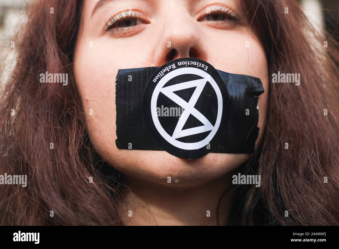 London, UK - 16 October 2019. A climate activist from Extinction rebellion tapes her mouth during  a protest vigil in Trafalgar Square to demonstrate against section 14 of the public order act 1986 impose by the Police banning protests. Extinction Rebellion has sought a judicial review to challenge a London-wide protest ban in the High courts Credit: amer ghazzal/Alamy Live News Stock Photo