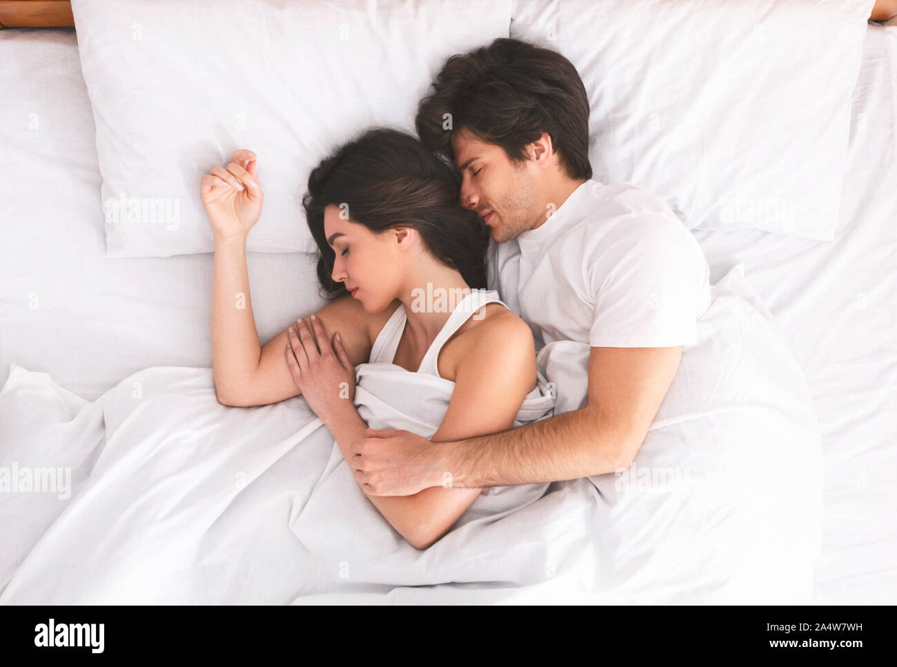 Loving married couple sleeping in bed and hugging Stock Photo Alamy