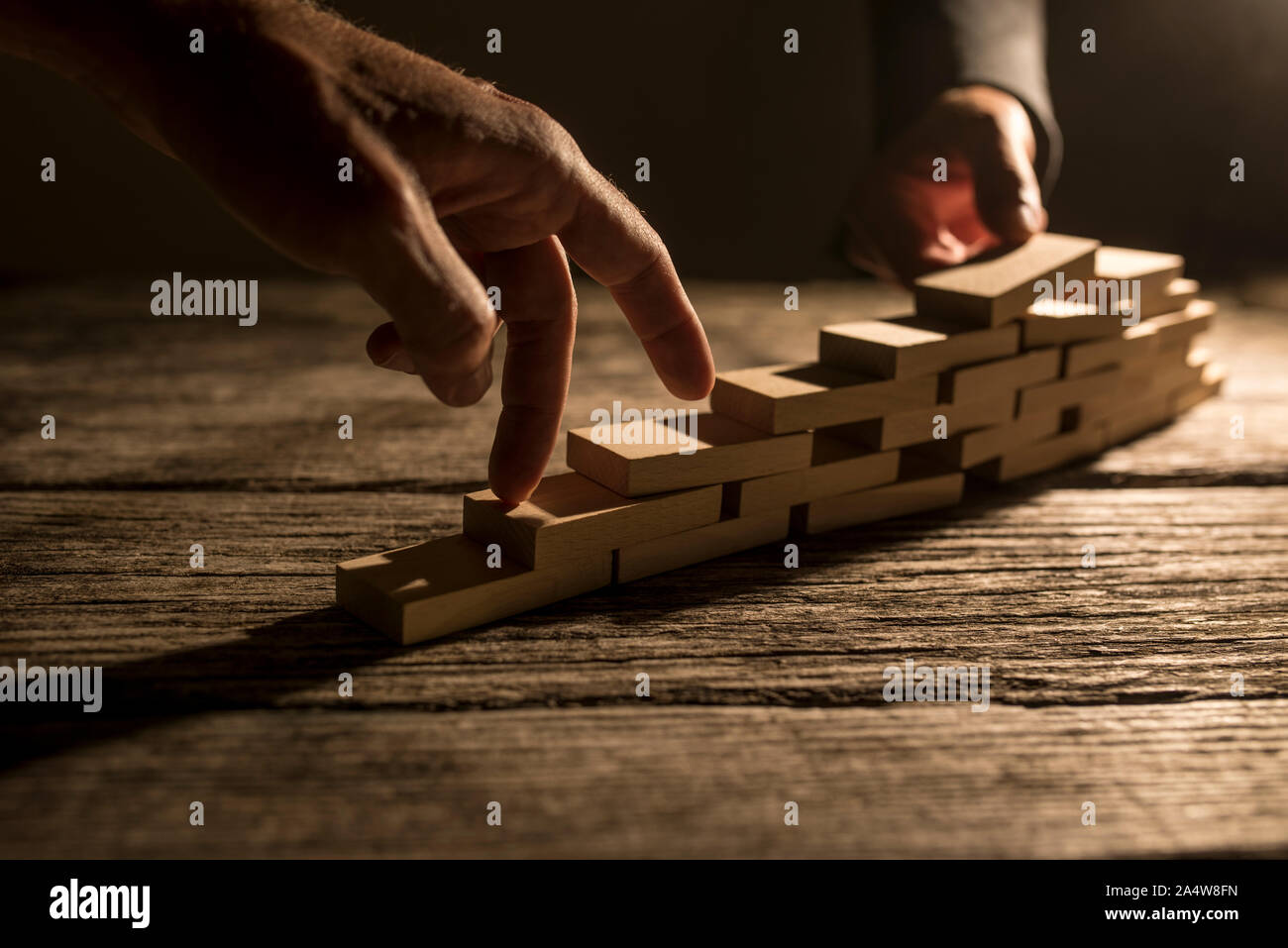 Pair of fingers walking up wooden blocks for concept about overcoming difficulty and achieving goals. Stock Photo