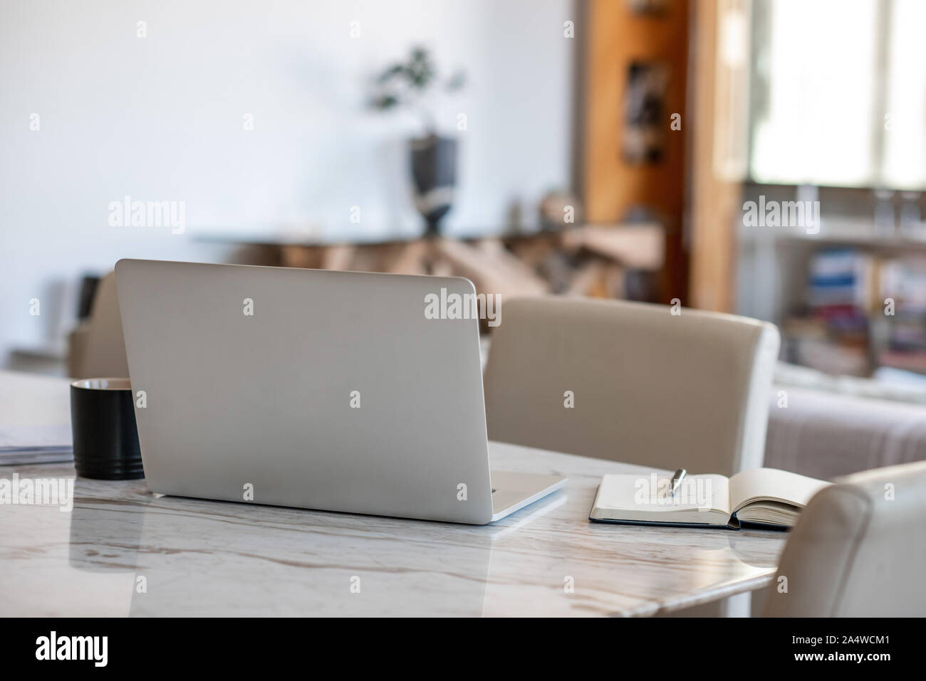 Laptop and notebook sitting on an apartment table Stock Photo