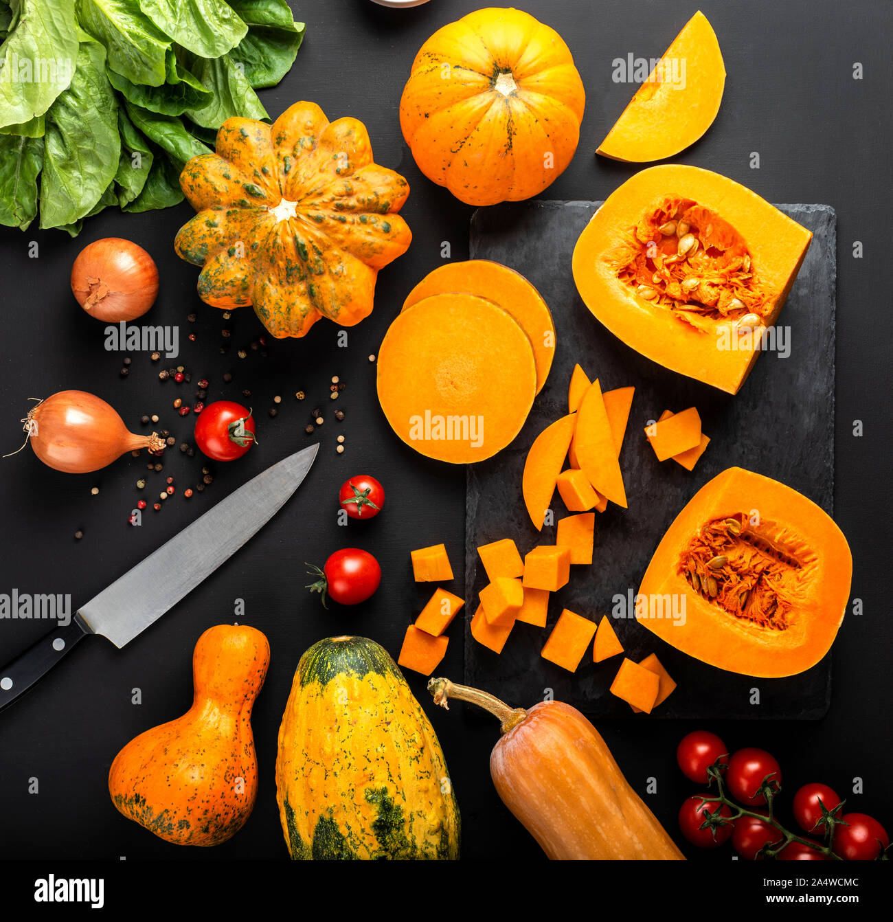 Different types of pumpkins and other vegetables on a black background ...