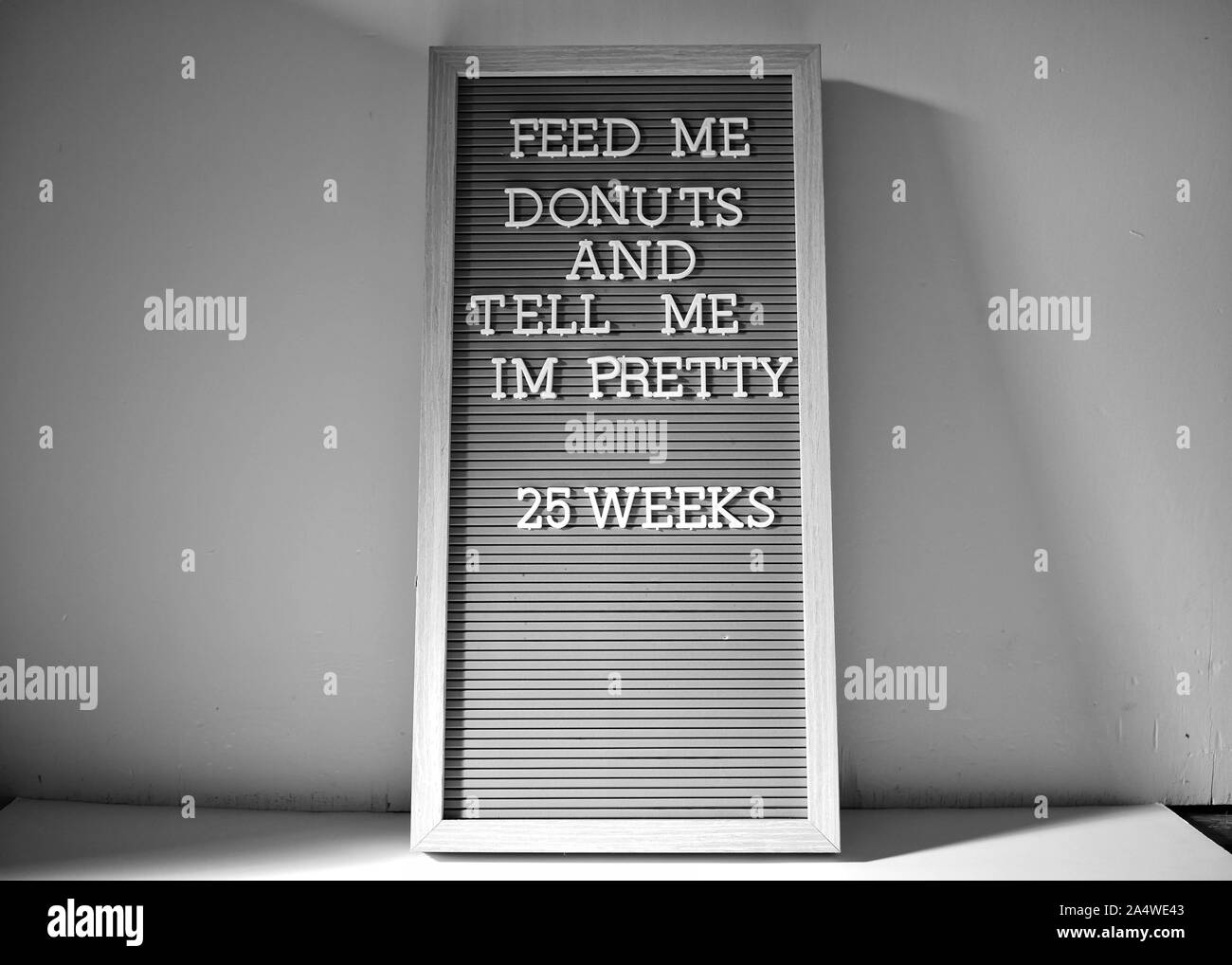 25 weeks pregnant sign in black and white with nice shadows. The cravings are real. Stock Photo