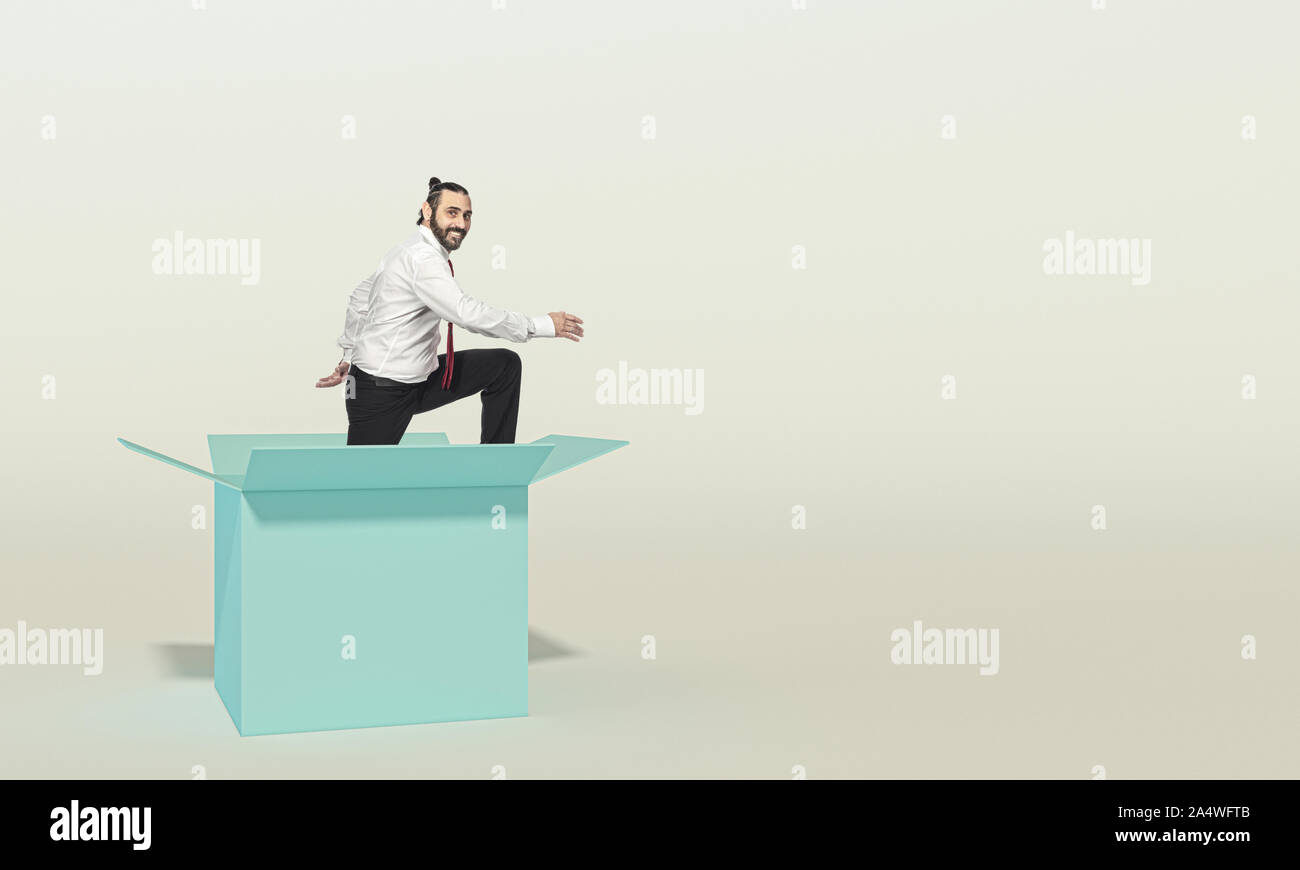 smiling businessman looks in the room as he comes out of a box. concept of different thinking and innovation. Stock Photo