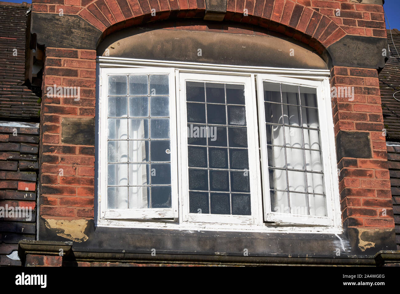 traditional original white painted leaded wooden windows in a building in Port Sunlight England UK Stock Photo