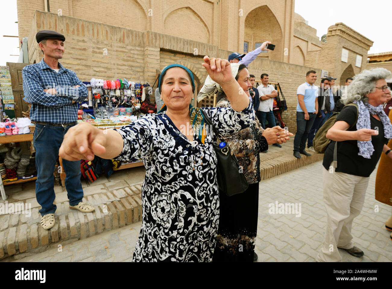 Dancing guests during a wedding in the main street of the old town of Khiva, a very popular site for all the festivities in the town. Uzbekistan Stock Photo