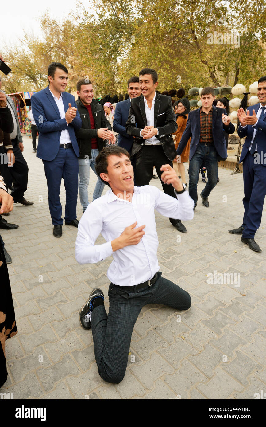 Dancing guests during a wedding in the main street of the old town of Khiva, a very popular site for all the festivities in the town. Uzbekistan Stock Photo