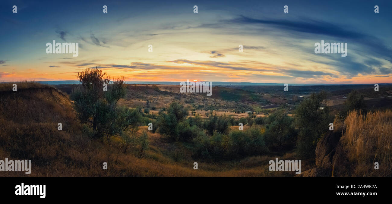 Soft autumn sunset panorama over countryside hills and valley. Beautiful rural landscape, nature scene. Stock Photo