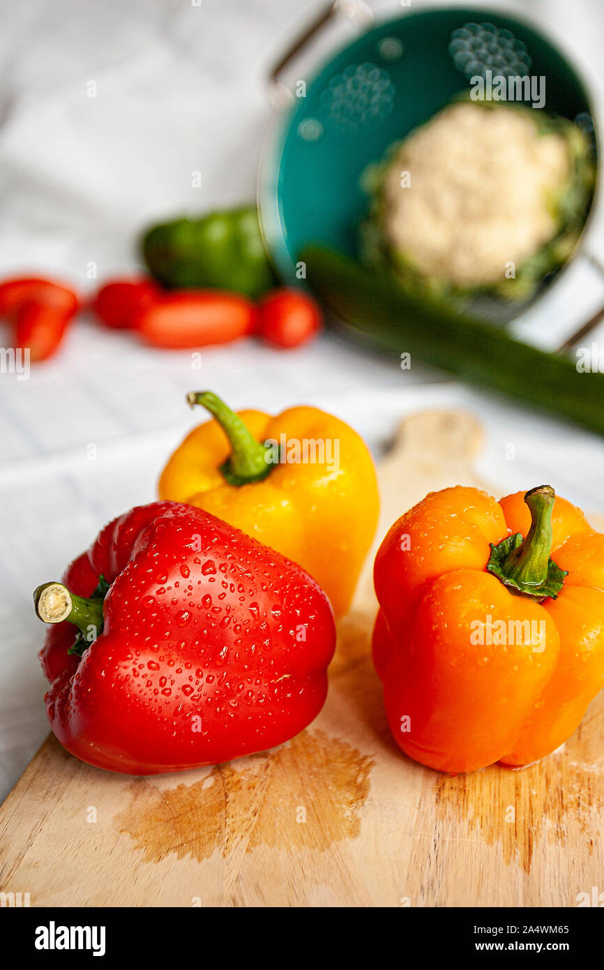 Colored Peppers on chopping board Stock Photo - Alamy