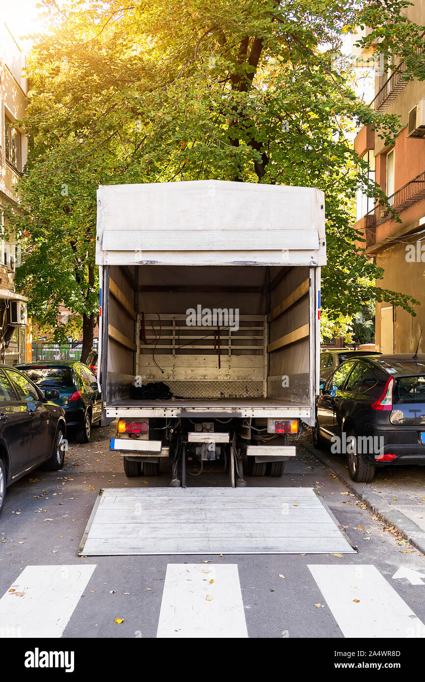 Open furniture delivery truck on a city street. Empty moving van with rear  doors opened. On an autumn sunny day. Back view Stock Photo - Alamy