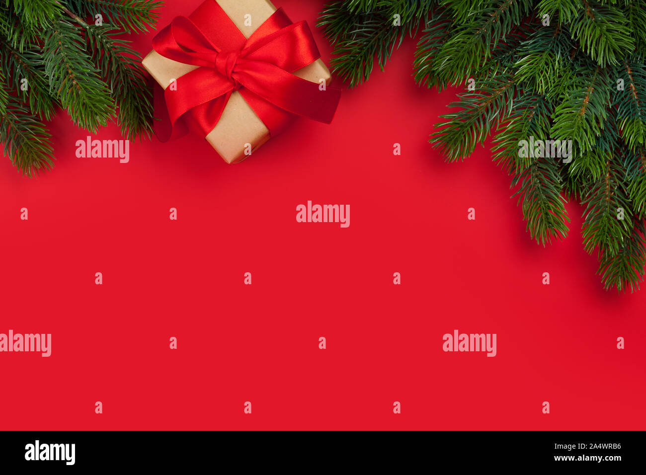 Christmas greeting card with gift box and fir tree branch over red ...