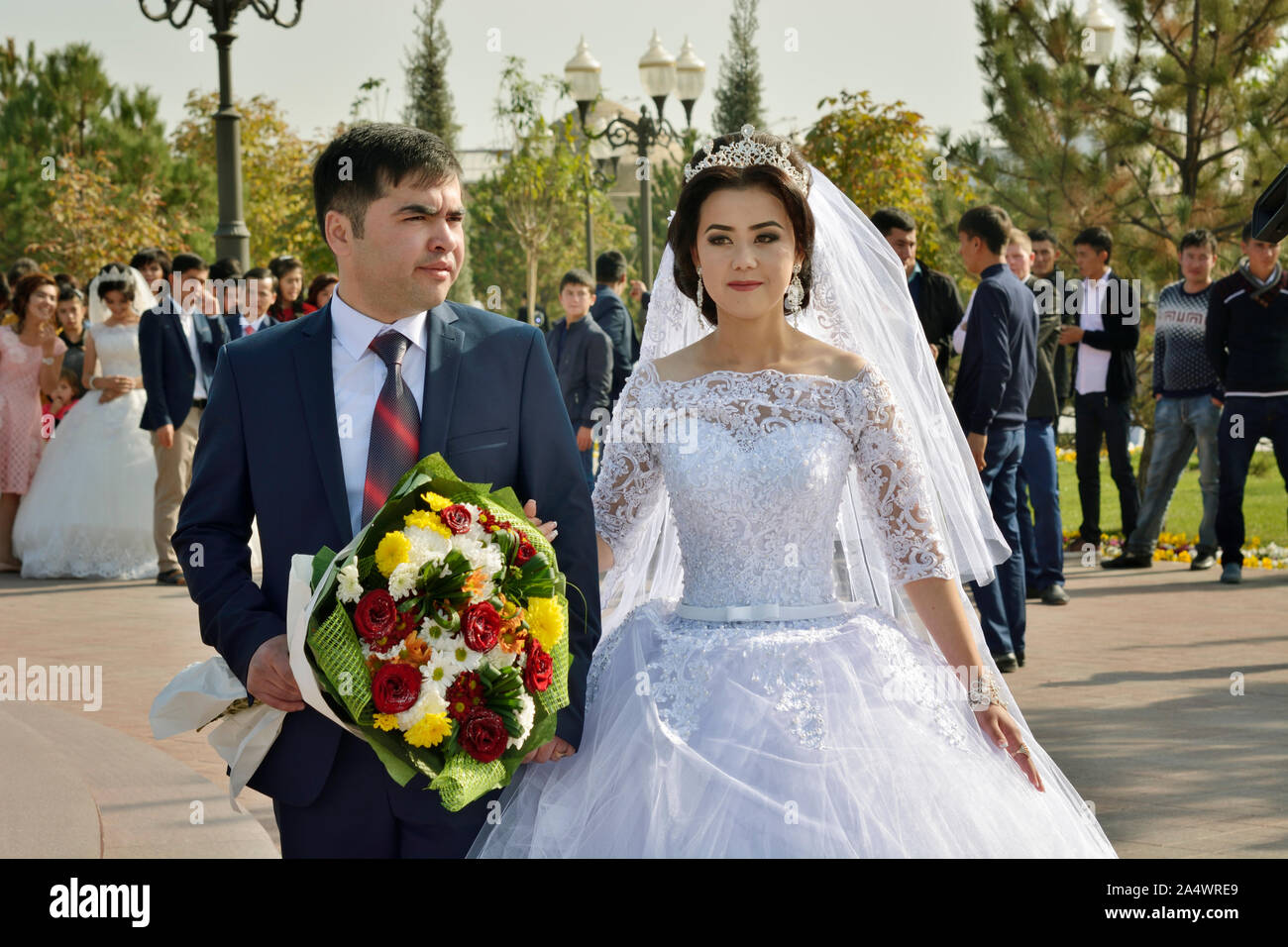 A wedding in front of the statue of the late leader Islam Karimov, a must for the photo sessions. Samarkand, Uzbekistan Stock Photo
