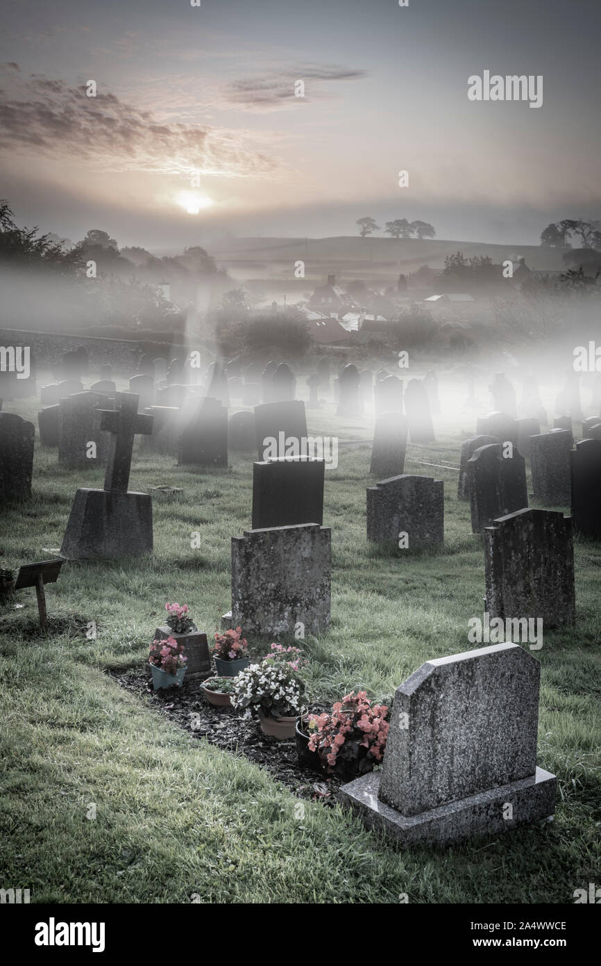 A ghostly apparition appears above the headstones in a moonlit graveyard. Stock Photo