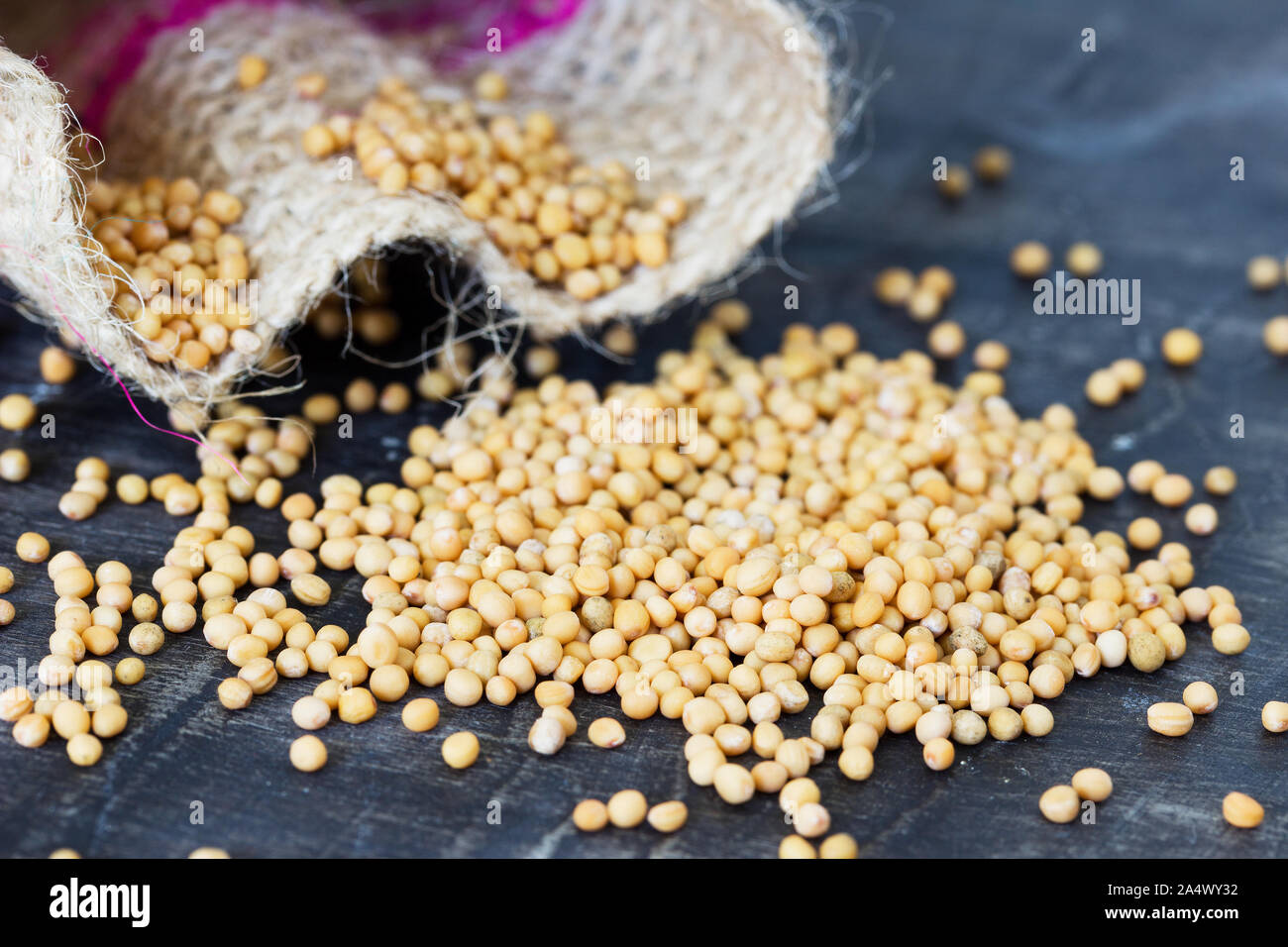 Seeds of yellow mustard on a wooden table Stock Photo