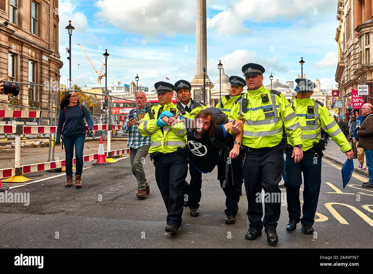 London, U.K. - Oct 16, 2019: An environmental campaigner from Extinction Rebellion is dragged away by Police after blocking a road in Trafalgar Square. Stock Photo