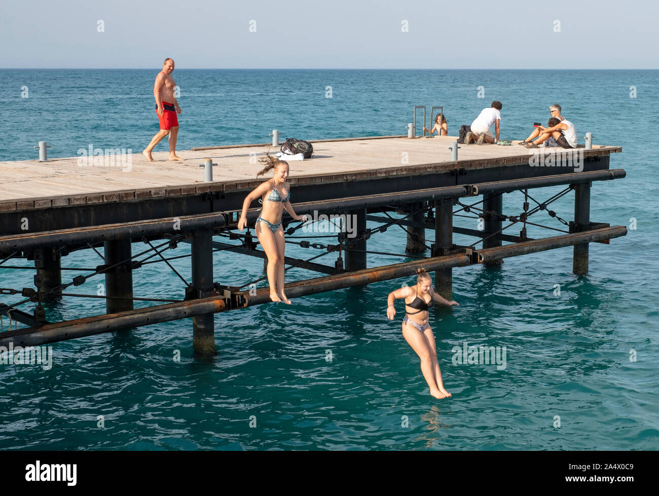 Swimmers jumping and diving into the water off Limni Pier, Argaka, Polis, Cyprus. Stock Photo