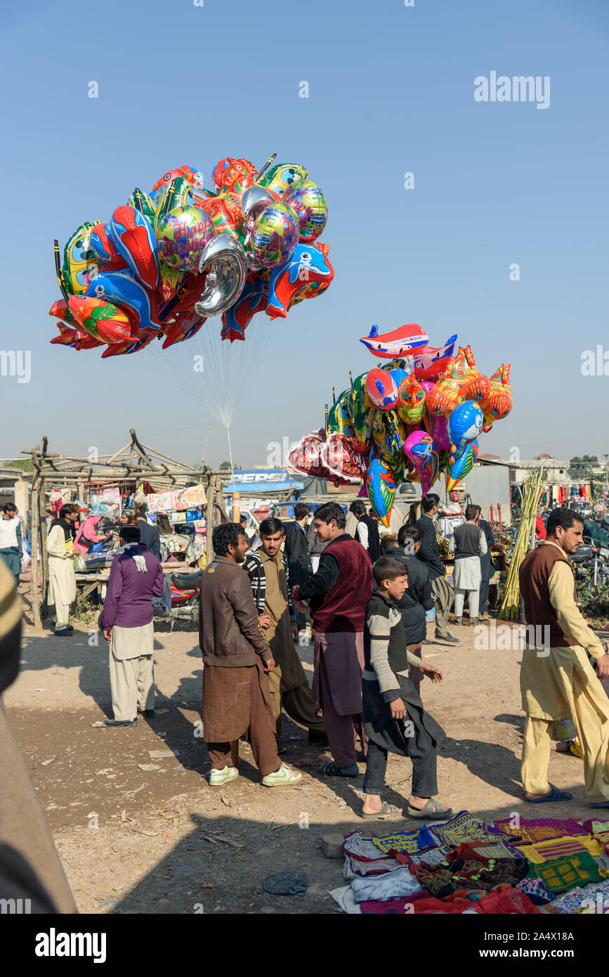 PESHAWAR PAKISTAN, DECEMBER 13, 2015: Boy selling his foil balloons in sunday market at Hayatabad town in Peshawar Pakistan Stock Photo