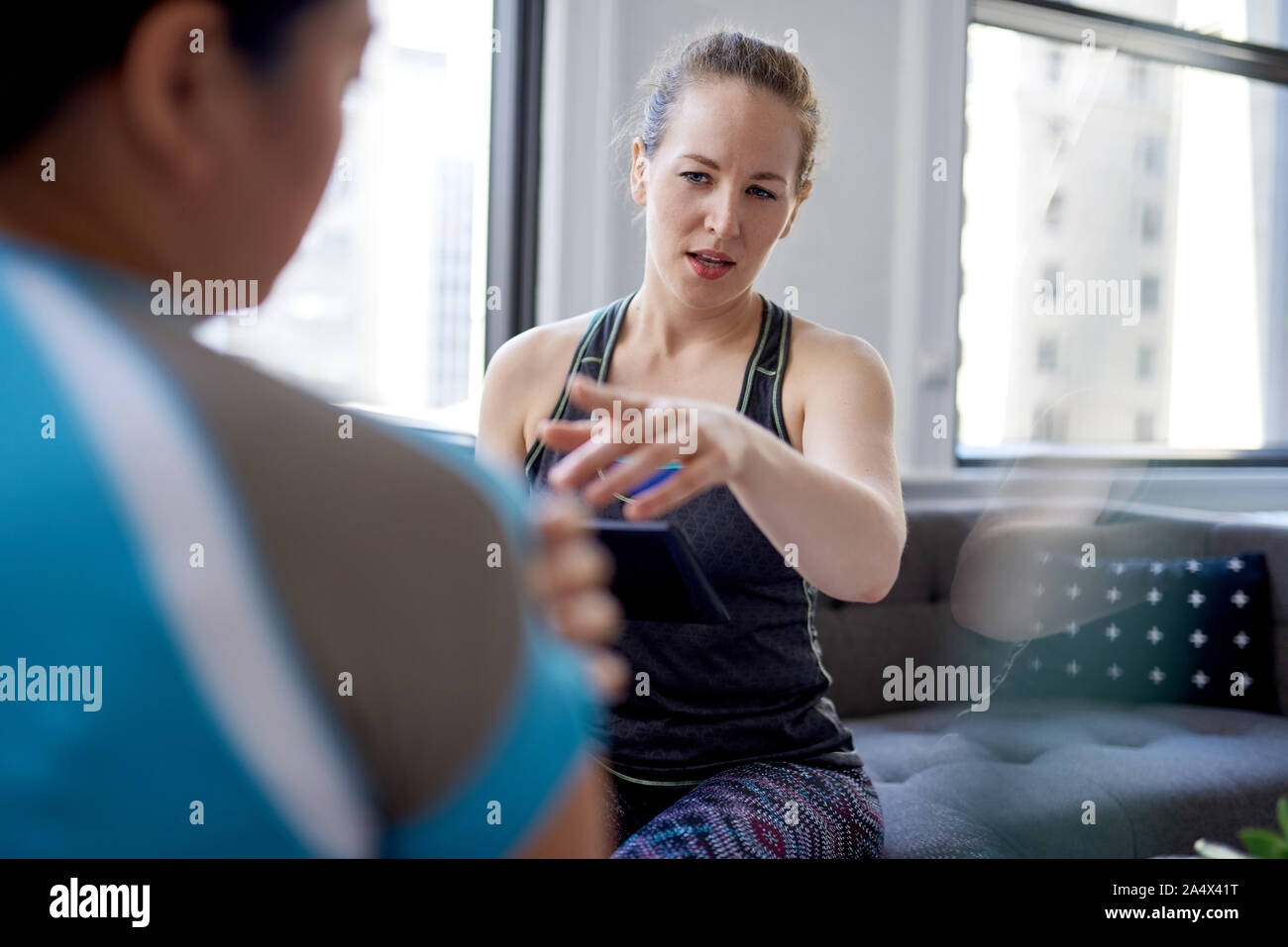 Caucasian woman physiotherapist talking to a mid-adult chinese f Stock Photo