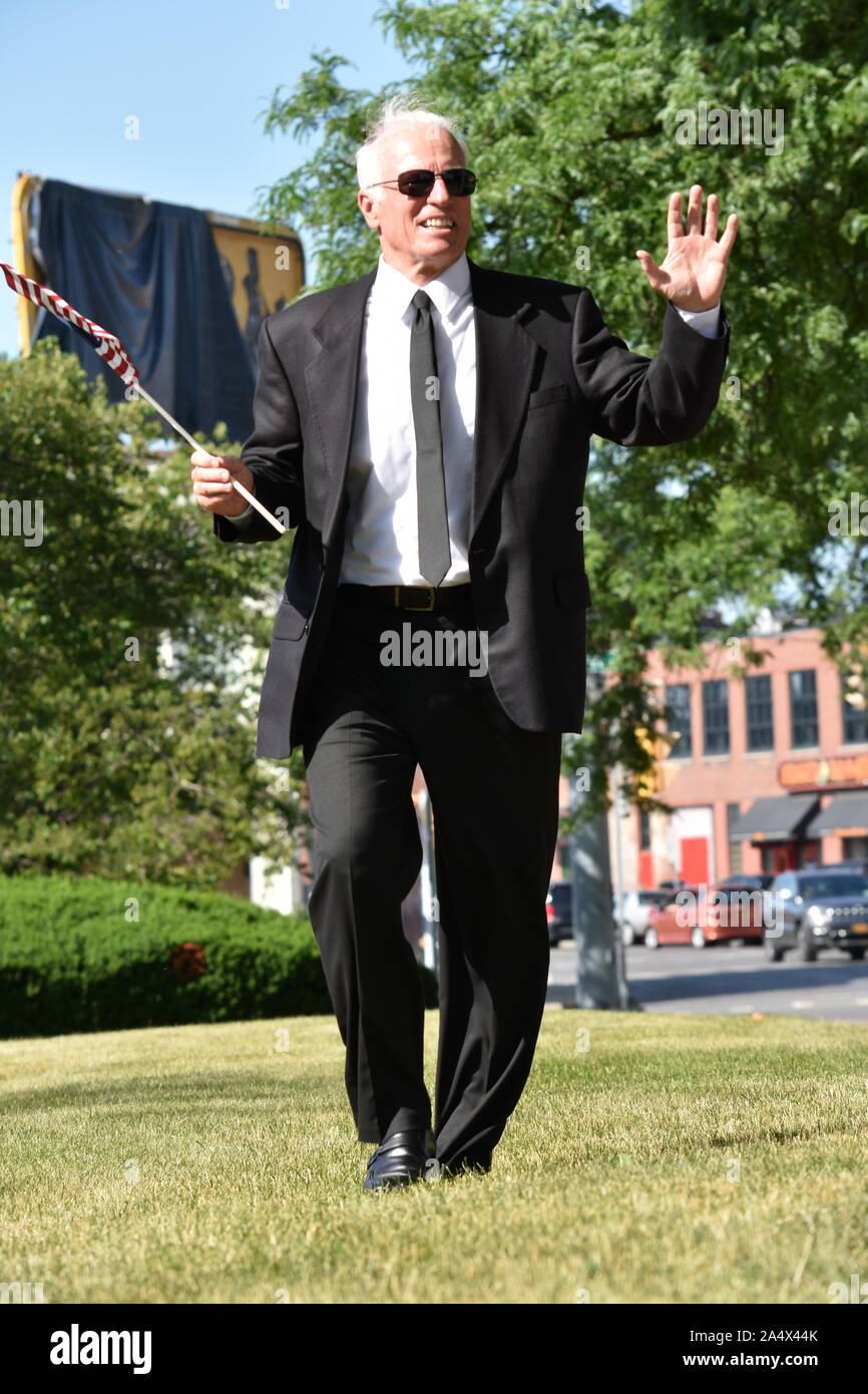 Political Candidate Portrait With Flag Walking Stock Photo