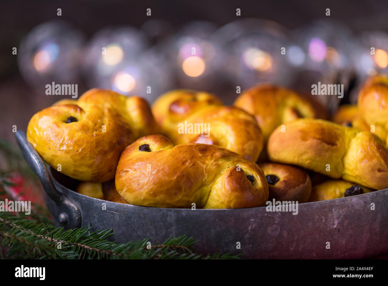 A tray of freshly baked homemade Swedish traditional saffron buns, also known as lussekatter or lussebullar. The yellow buns have raisins and are shap Stock Photo