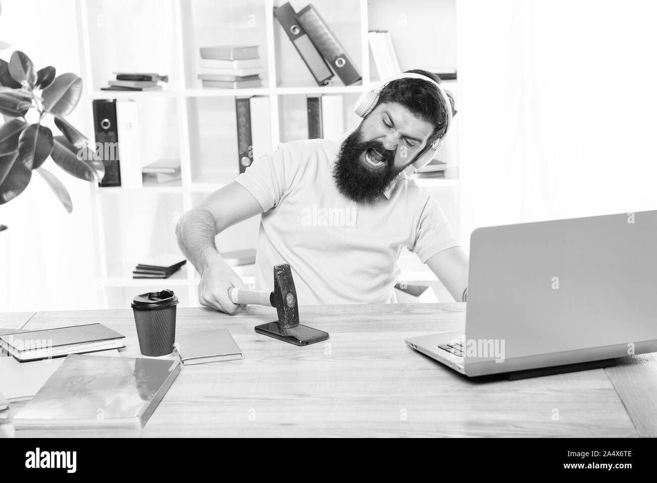 Spoiled communication. Failed mobile negotiations. Most annoying thing about work in call center. Incoming call. Annoying client calling. Man bearded guy headphones office swing hammer on smartphone. Stock Photo