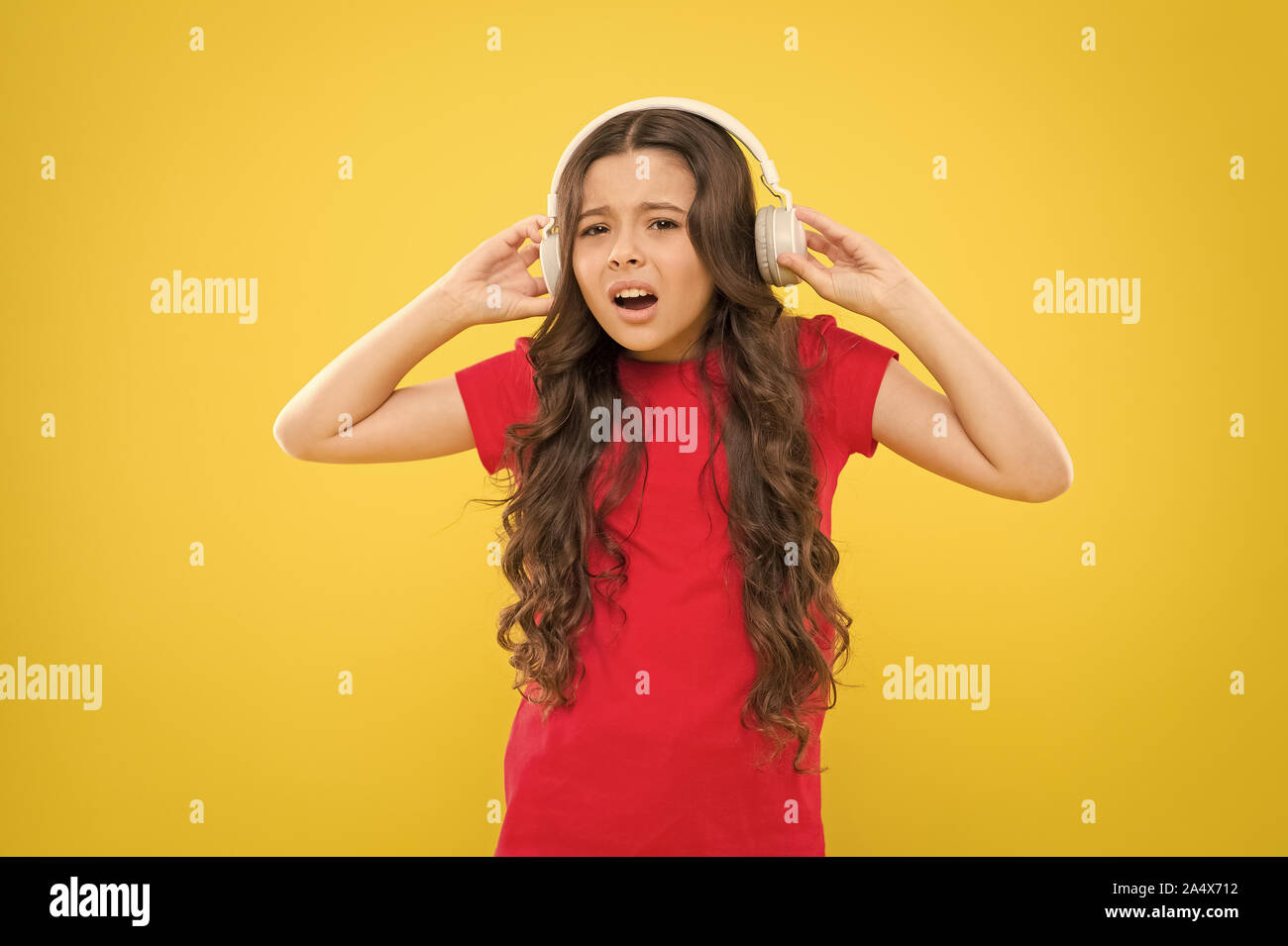 Why do my headphones sound low. Little girl wearing headphones on