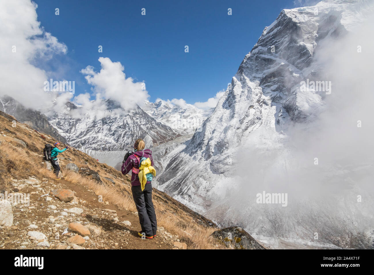 Women mountaineers pose for photos among spectacular mountain backdrop Stock Photo