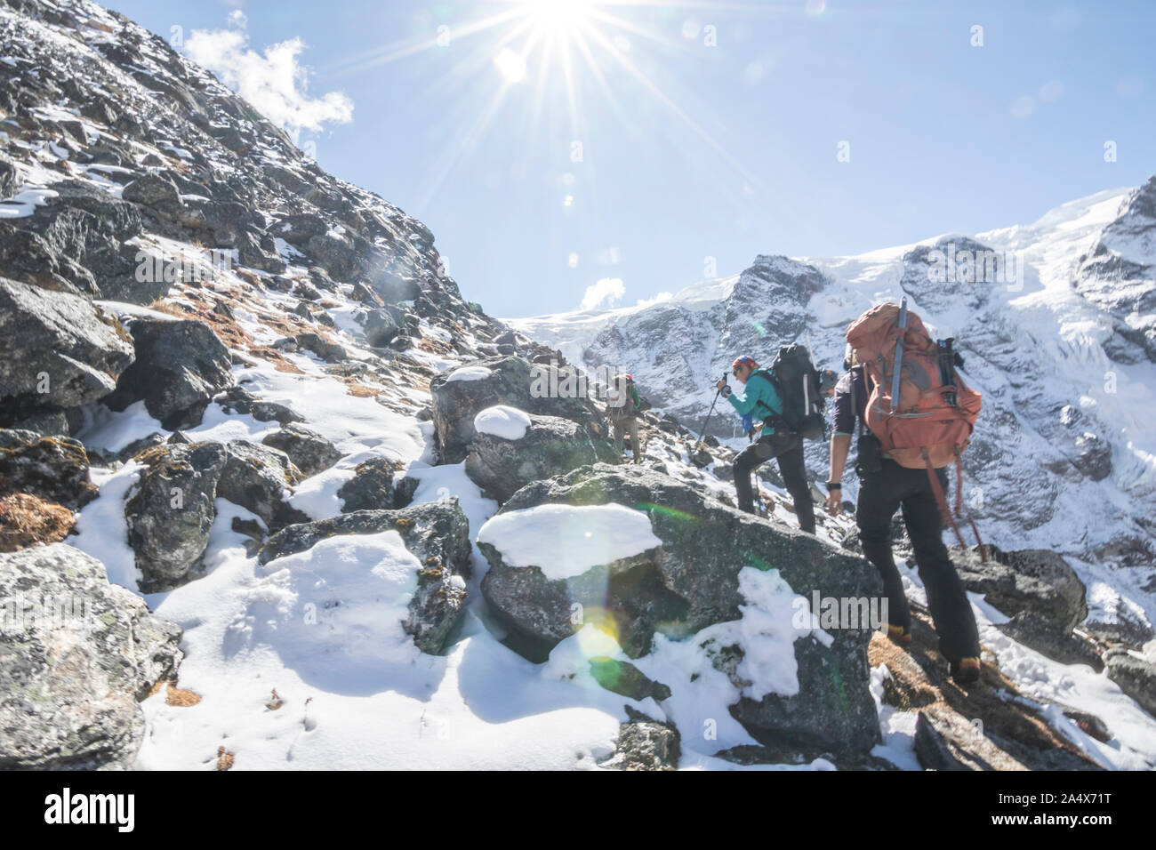 Two women mountaineers ascend through a snowy boulder field Stock Photo