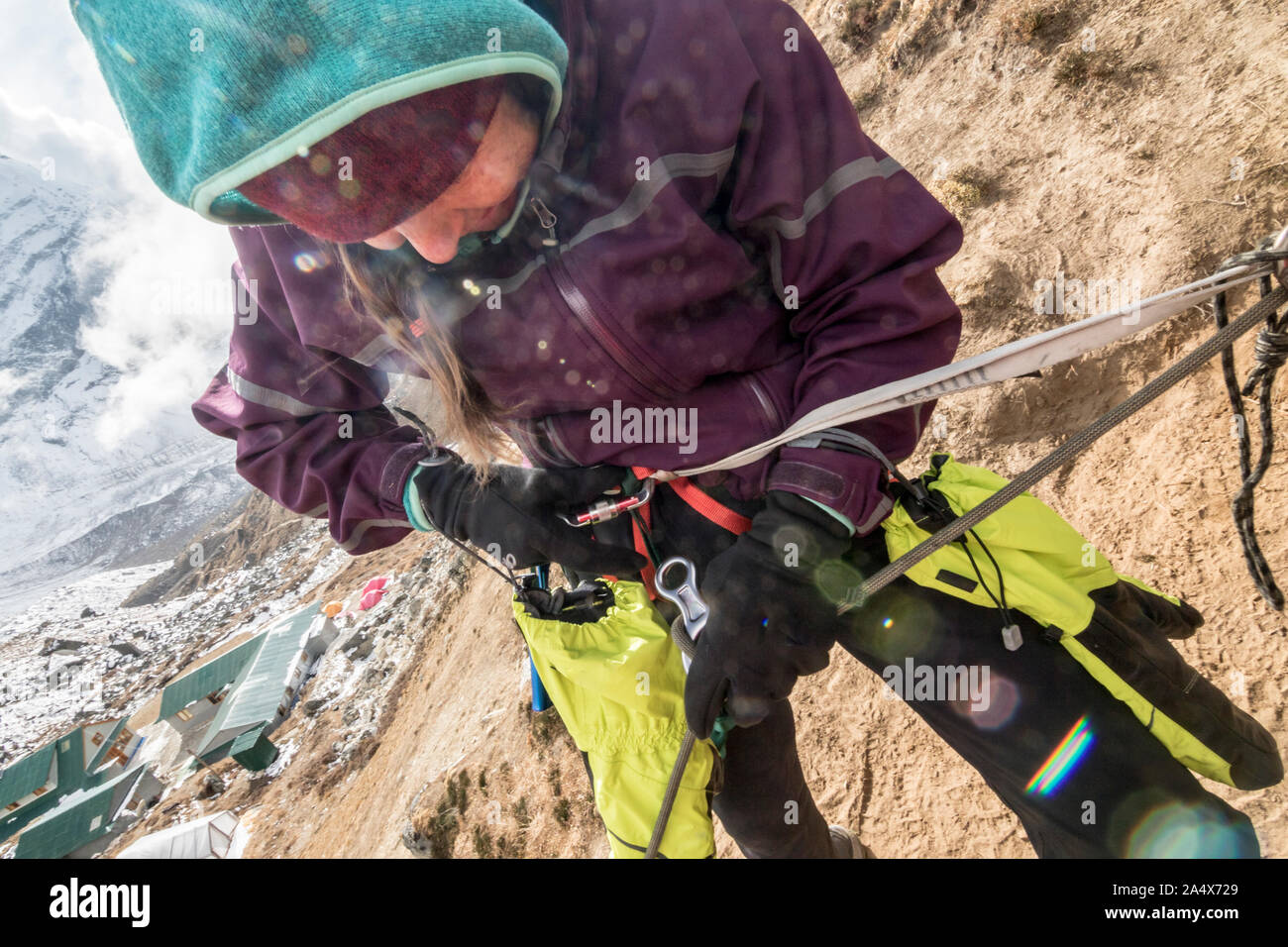 A woman climber engages her figure 8 rappel device Stock Photo