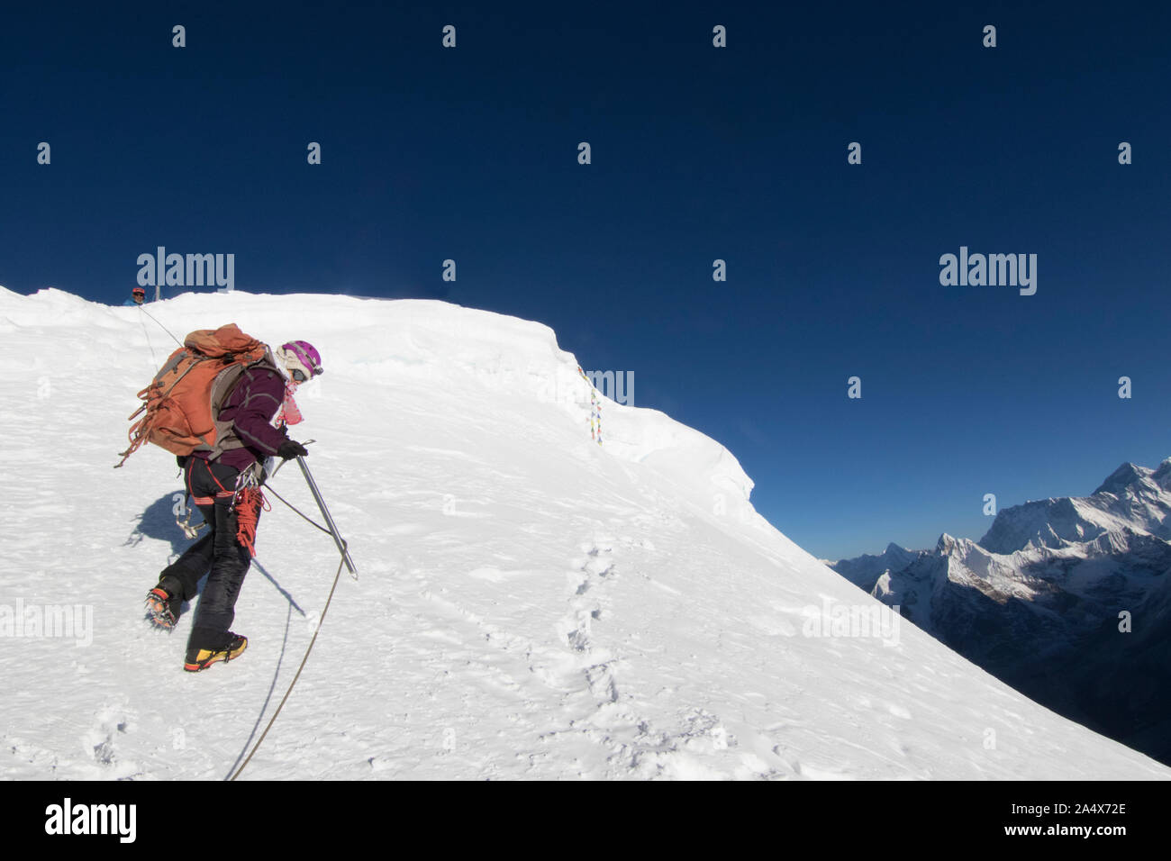 Woman climber ascends the final meters to Mera Peak's 21,247ft summit Stock Photo