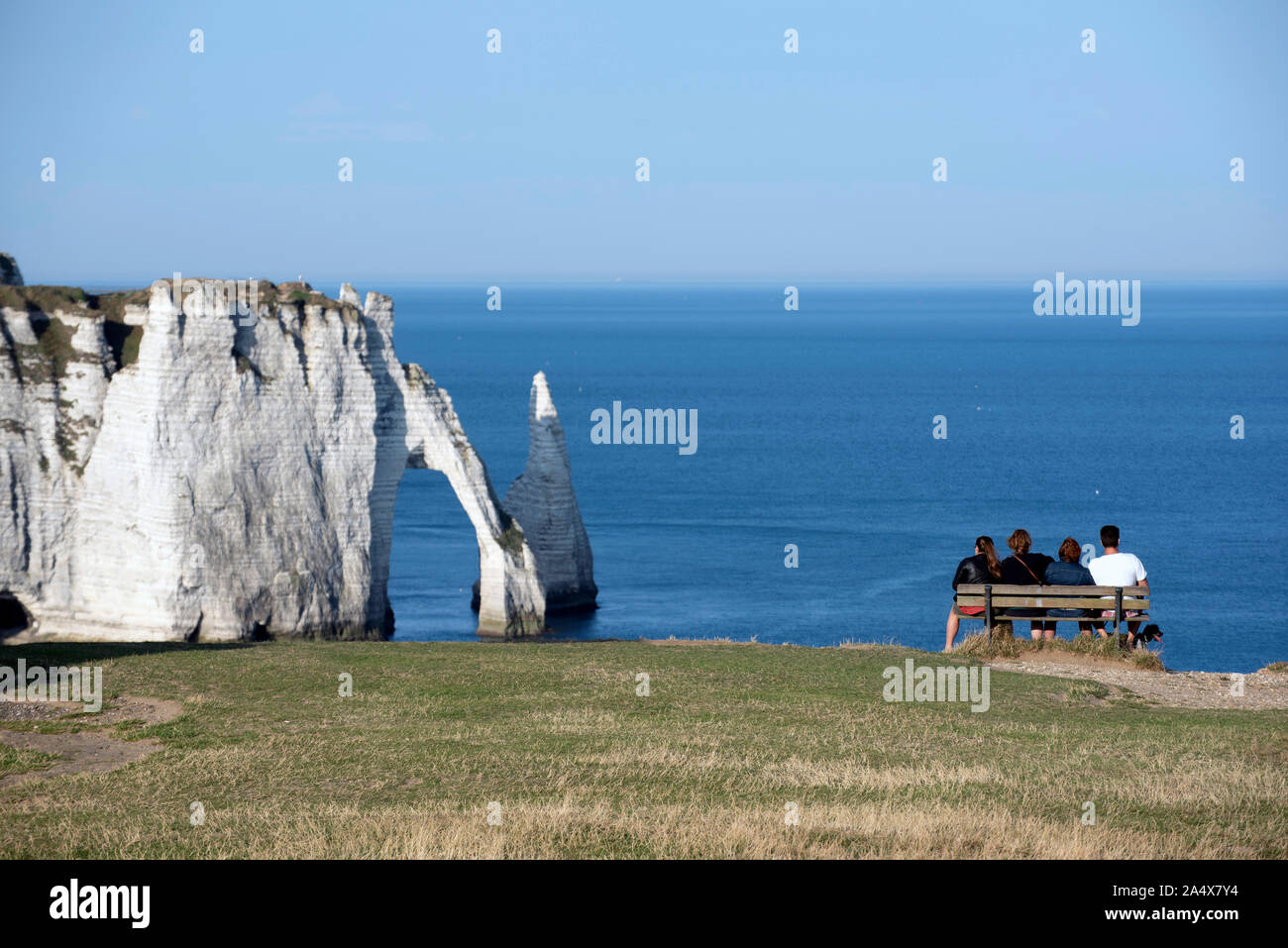 Four people enjoying the views of the Cliffs of Etretat, Normandy, France. Stock Photo