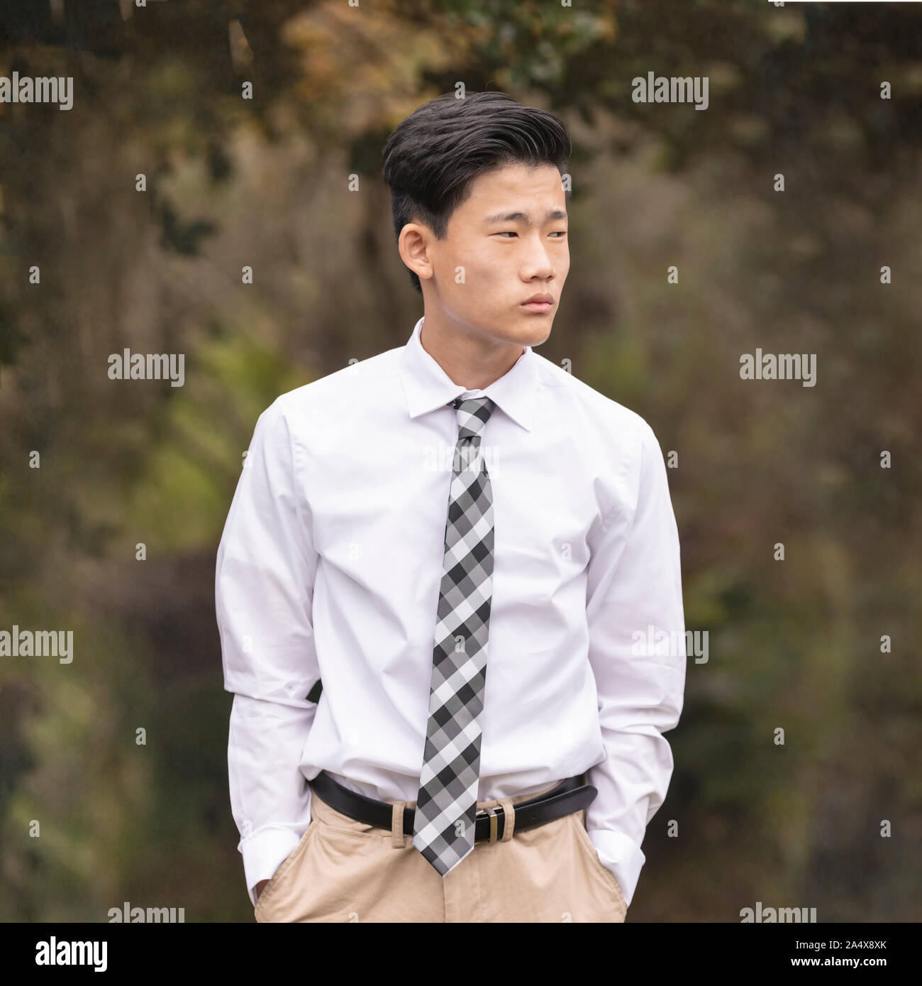 Asian Chinese teenage boy in white dress shirt, tie and khaki pants Stock Photo