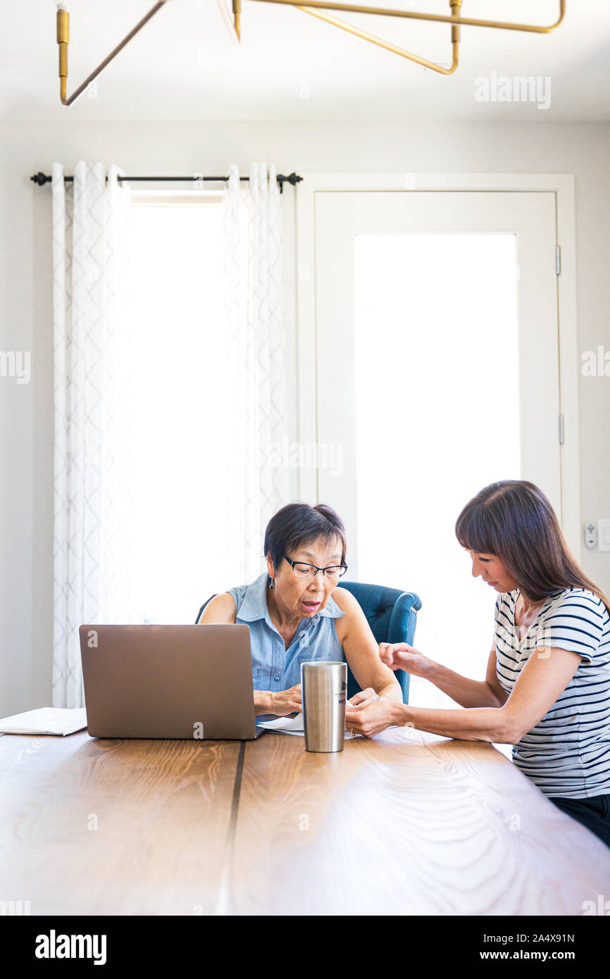 Daughter Explaining Paperwork To Mother Stock Photo