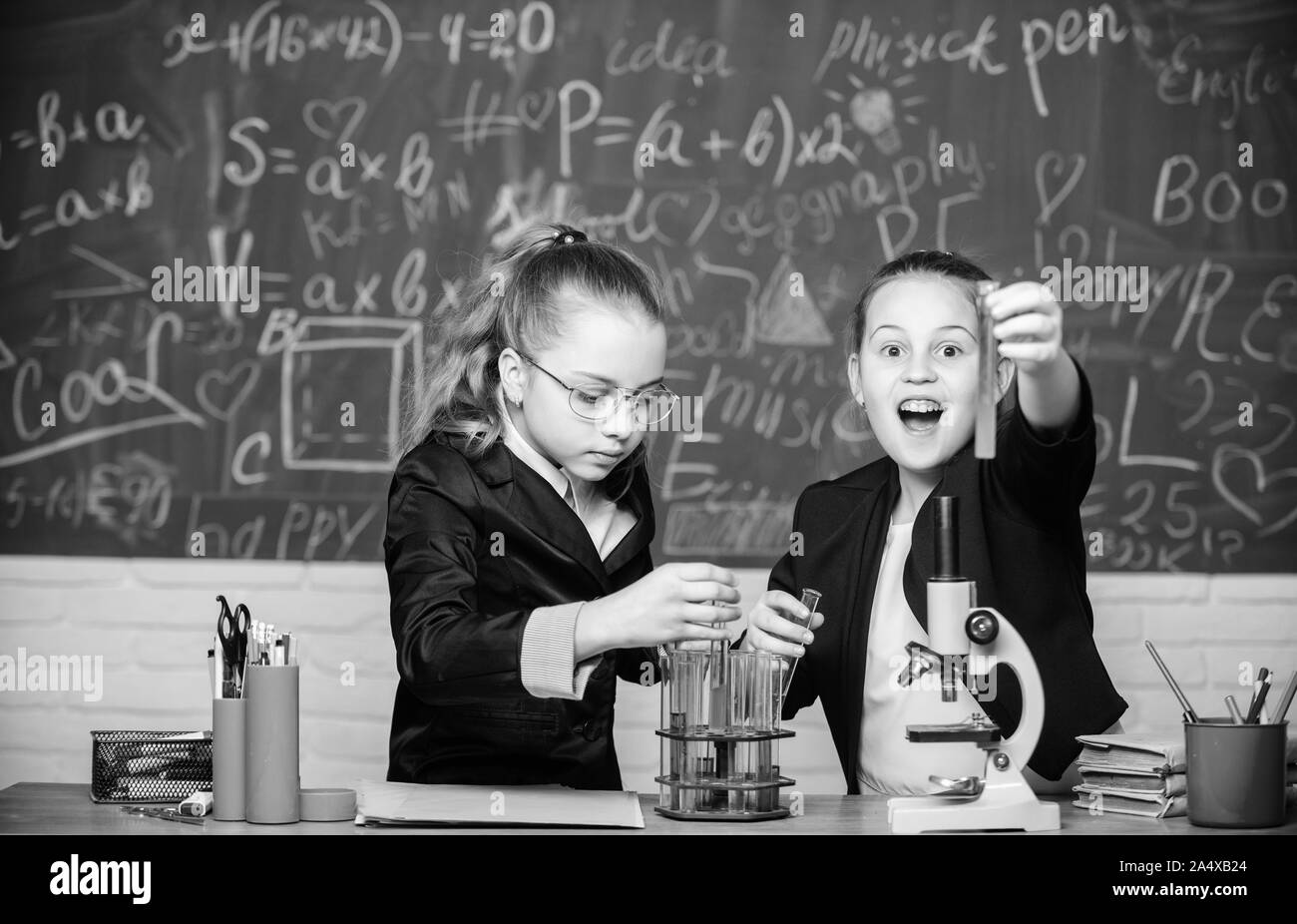 Girls school uniform busy with proving their hypothesis. School project investigation. School experiment. Science concept. Gymnasium students with in depth study of natural sciences. Private school. Stock Photo