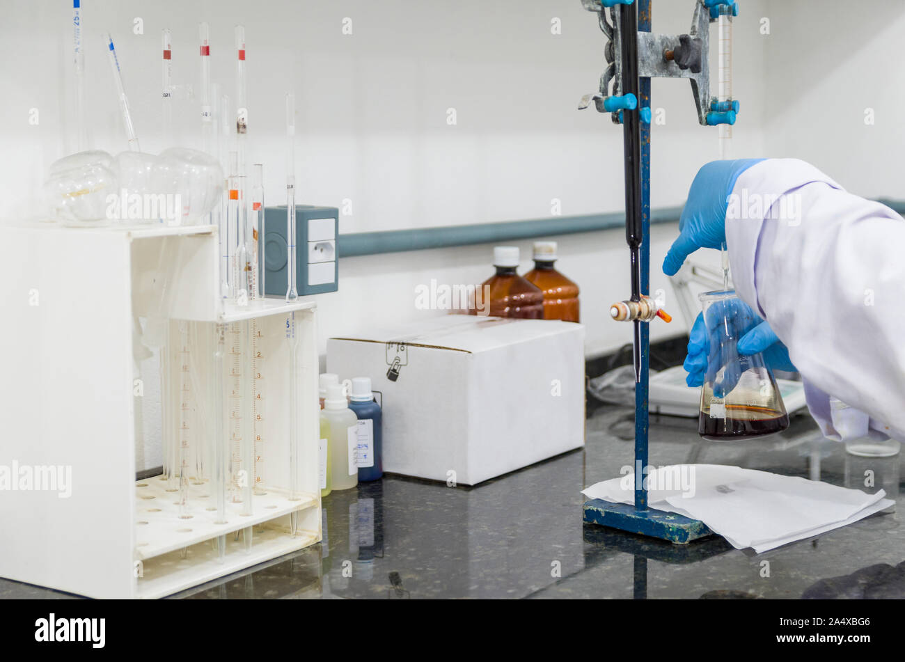 Woman hands performing titration test on chemical quality control Stock