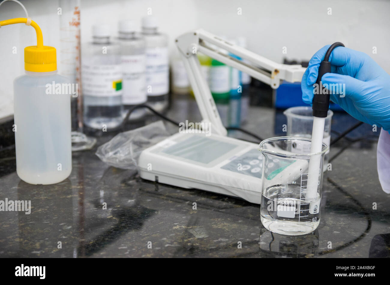 Woman hands performing pH test on pH meter electronic instrument for