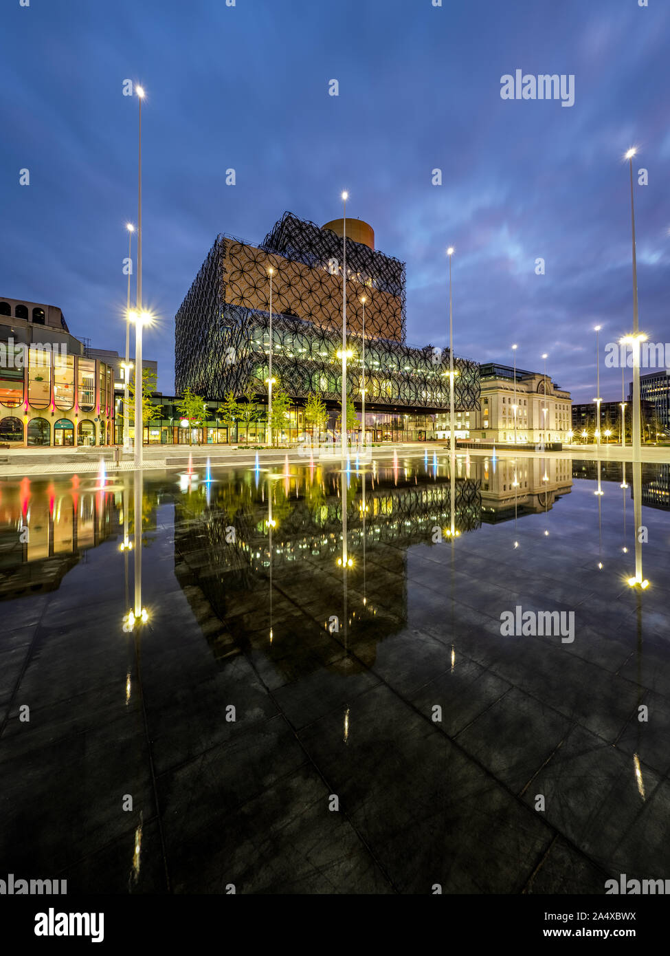 Library of Birmingham, Centenary Square, Birmingham, UK showing new water feature, illuminated before sunrise. Stock Photo