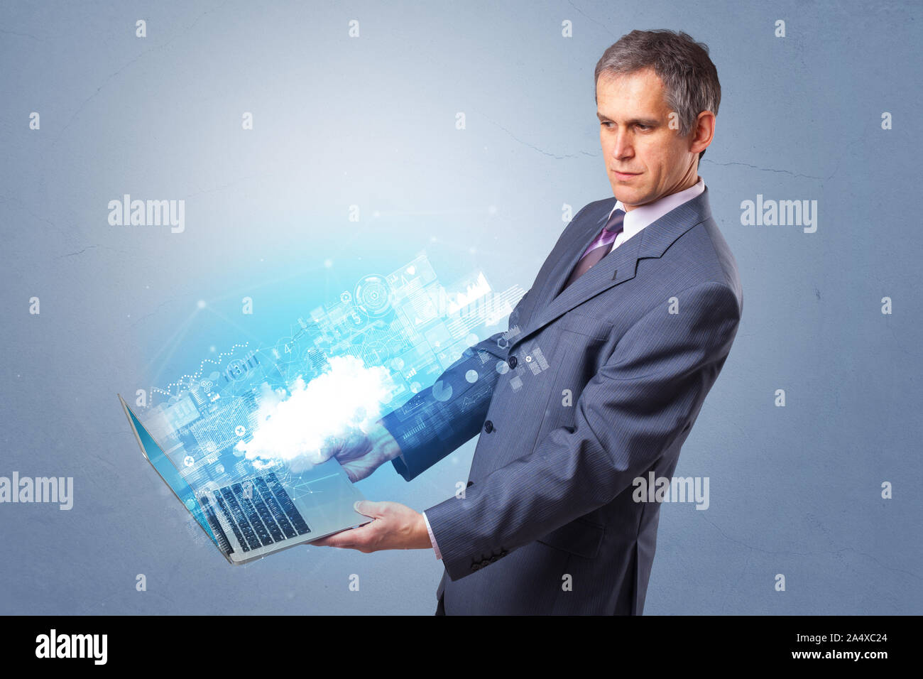 Man holding laptop projecting notifications, symbols and information based on cloud technology system Stock Photo