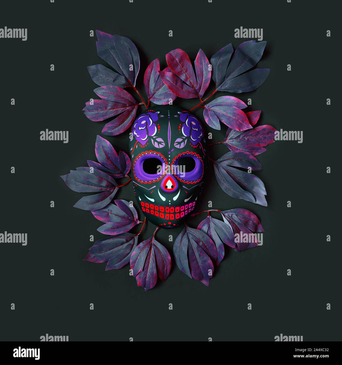 Sugar skull mask with flowers used for celebrating Day of the Dead in hispanic culture. Mexican symbol of the traditional Dia de los Muertos. Hallowee Stock Photo