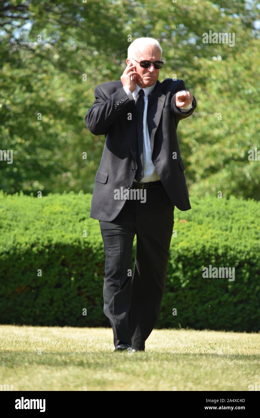 Senior Security Guard Pointing Wearing Sunglasses Walking Stock Photo