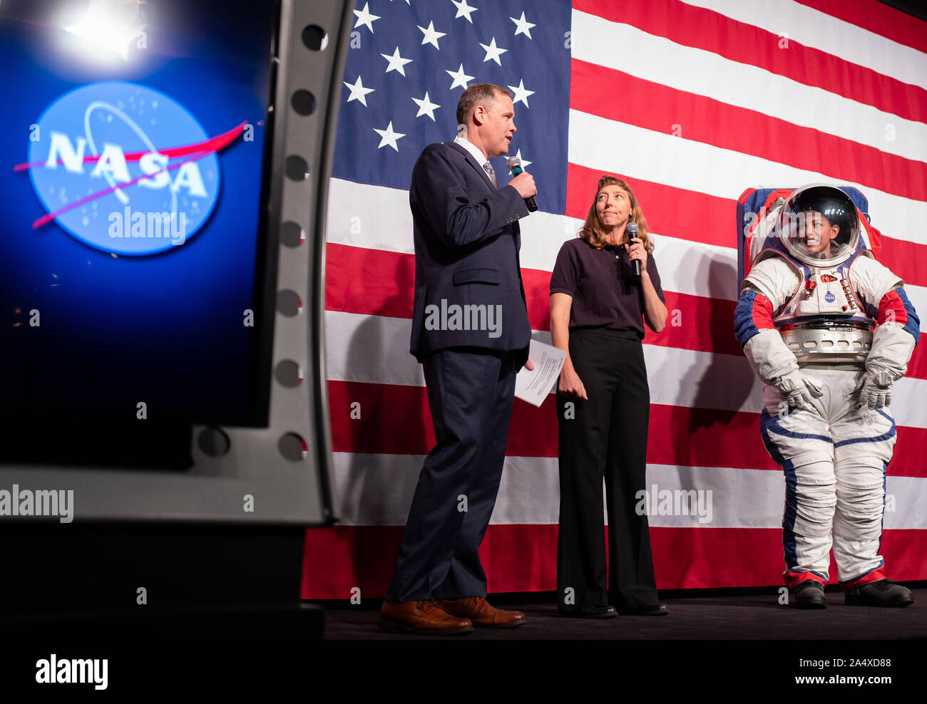 NASA Administrator Jim Bridenstine, left, and Amy Ross, a spacesuit engineer at NASA's Johnson Space Center, left, are seen with Kristine Davis, a spacesuit engineer at NASA's Johnson Space Center, wearing a ground prototype of NASA's new Exploration Extravehicular Mobility Unit (xEMU), during a demonstration of the suit, on October 15, 2019, at NASA Headquarters in Washington. The xEMU suit improves on the suits previous worn on the Moon during the Apollo era and those currently in use for spacewalks outside the International Space Station and will be will be worn by first woman and next man Stock Photo