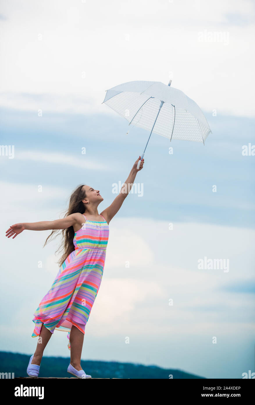 Touch sky. Girl with light umbrella. Fairy tale character. Happy childhood. Feeling light. Anti gravitation. Fly drop parachute. Dreaming about first flight. Kid pretending fly. I believe i can fly. Stock Photo