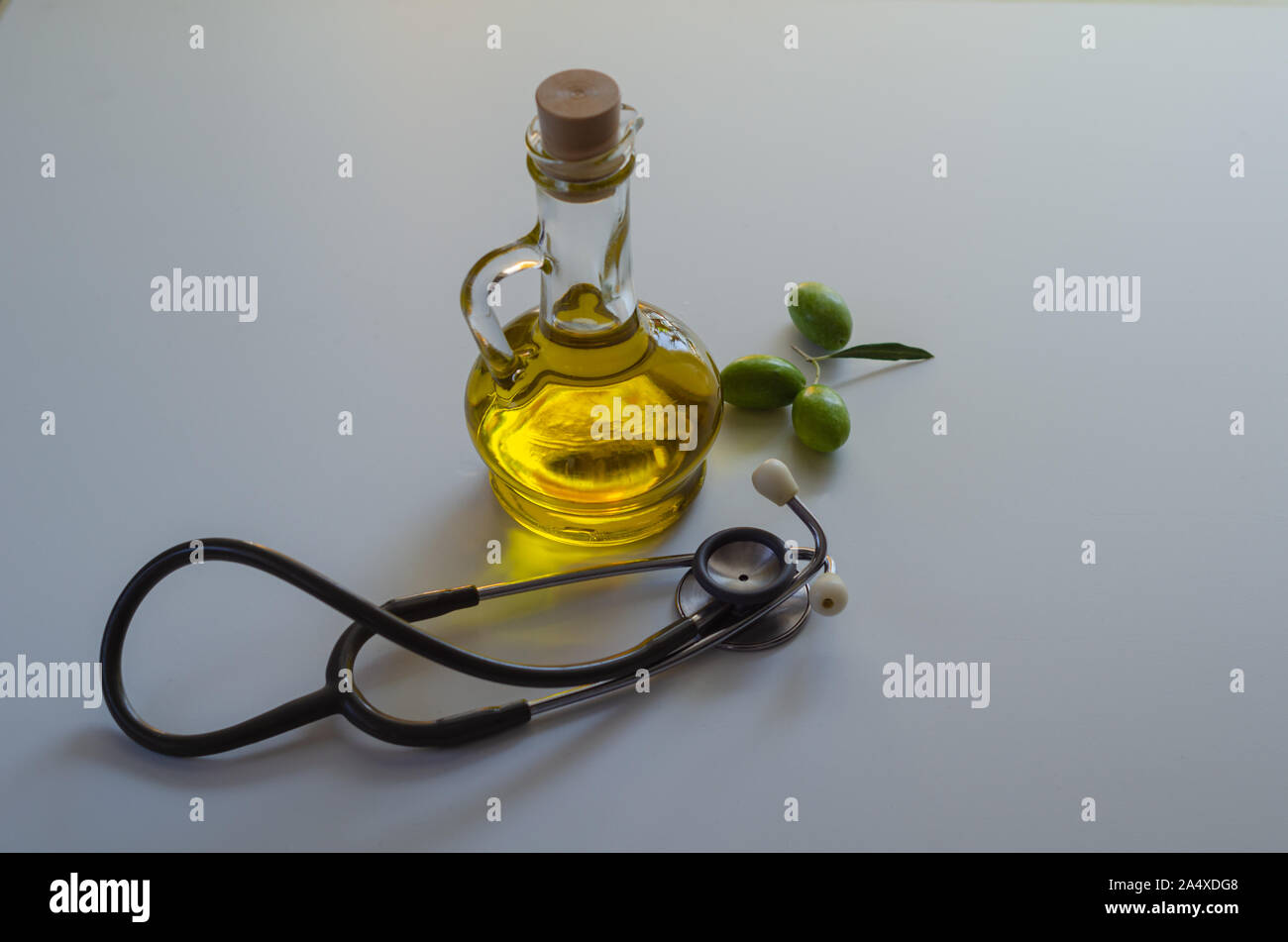 Olive oil, olives and stethoscope on white background. Heart health and