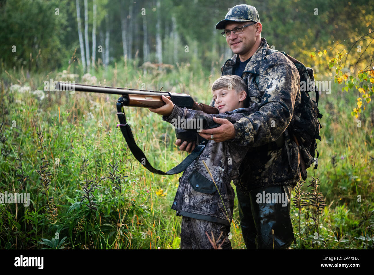 Father teaching his son about gun safety and proper use on hunting in