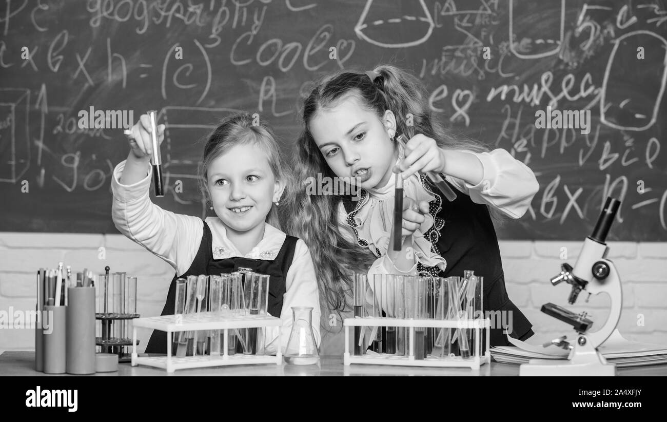 At chemistry school. School children performing experiment in science classroom. Schoolgirls holding test tubes. Science laboratory for school and education. Laboratory in elementary school. Stock Photo